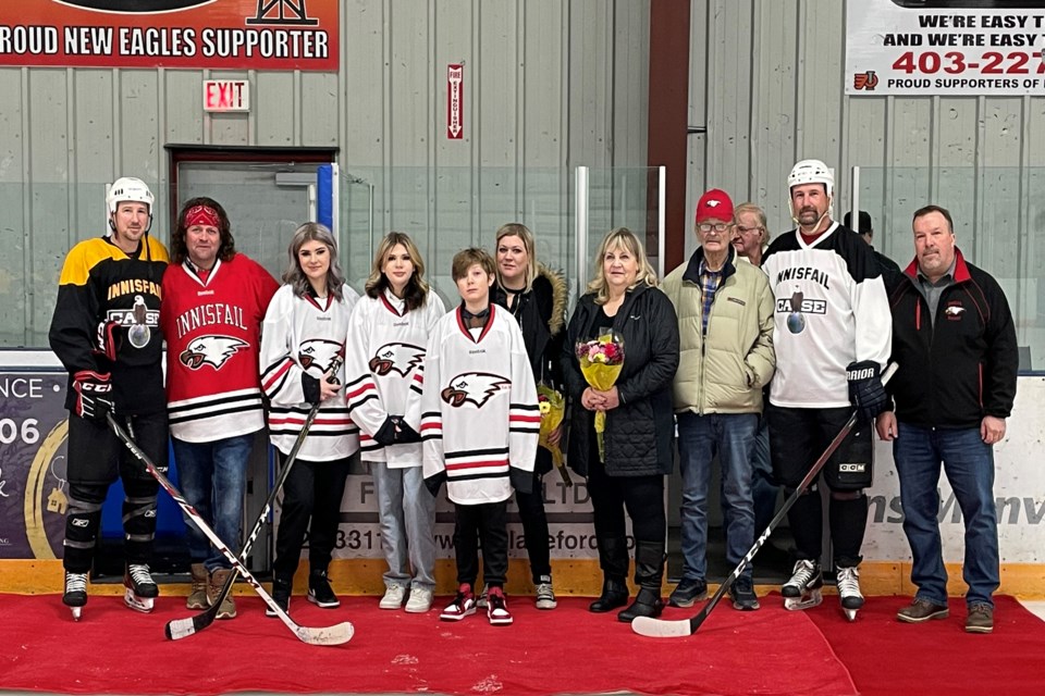 A group shot of the family of the late Tyler Haarstad, including Bailey Quirico, the mother of his three children Presley, Lennon, Jagger (white Eagles jerseys), younger brother Cody (red Eagles jersey) and parents Sherry and Everett Haarstad. Former Innisfail Eagle and emcee for the tribute Jason Lenz is at far right, with alumni representatives also included, one beside Lenz and another at far left beside Cody Haarstad. Johnnie Bachusky/MVP Staff